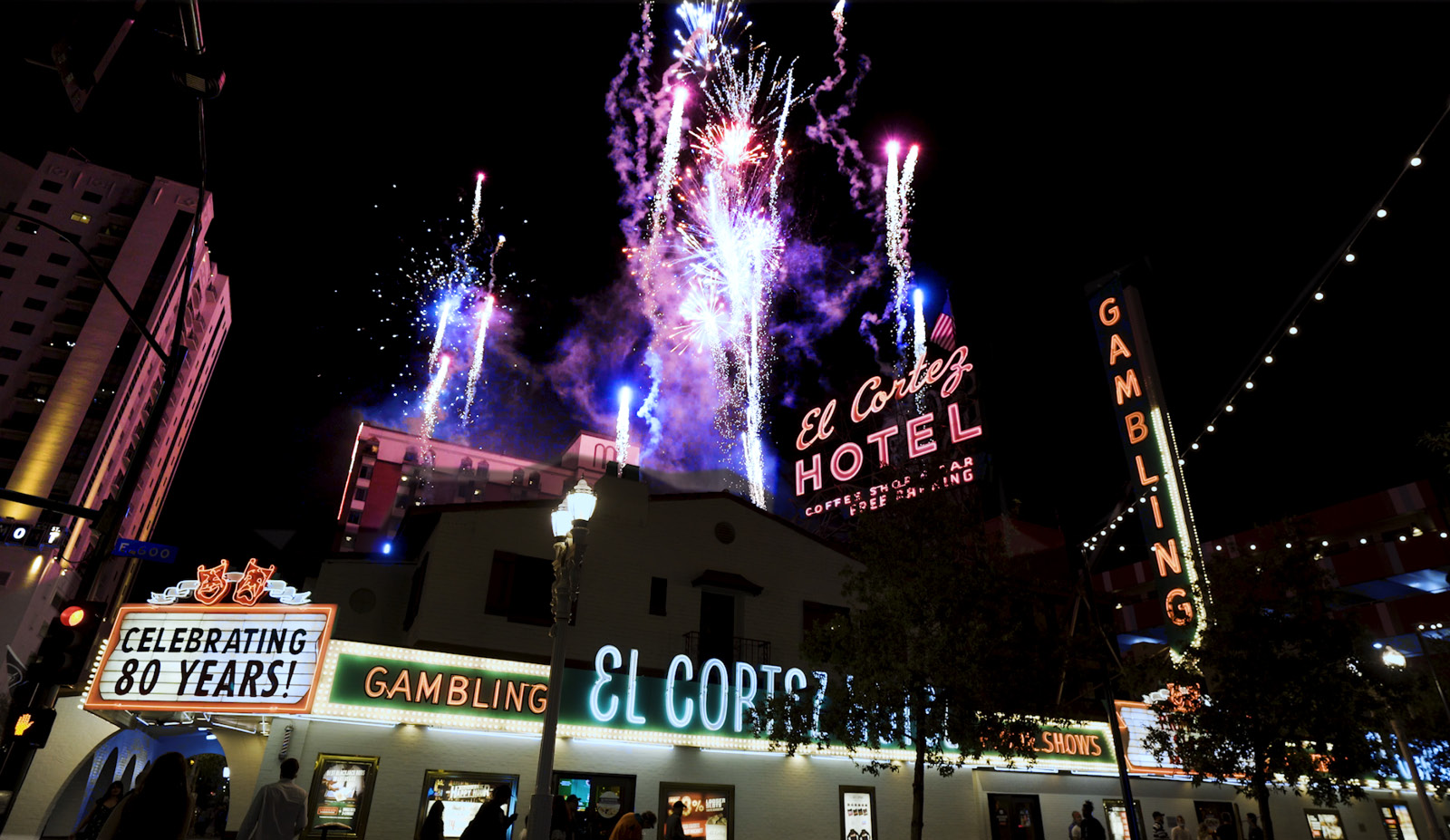 A nighttime view of the El Cortez Hotel and Casino with fireworks and neon signs.