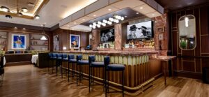 A curved marble bar with blue stools in the vintage-style interior of Siegel’s 1941.