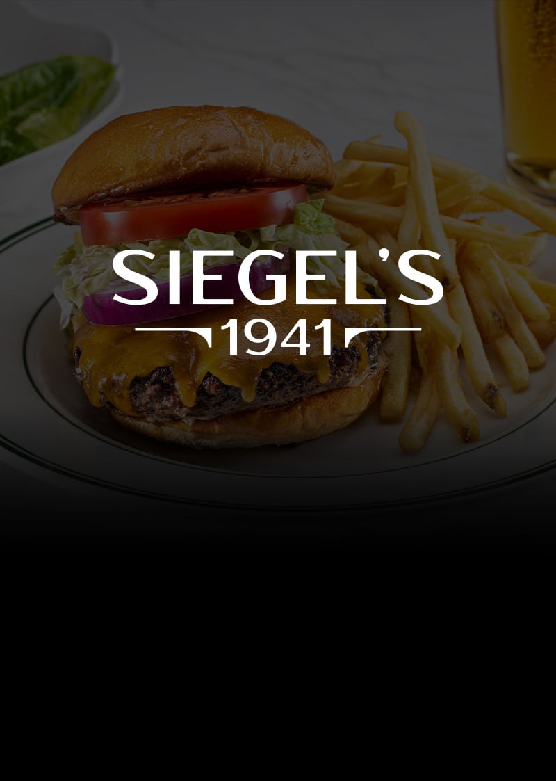 A cheeseburger and french fries on a plate from Siegel’s 1941.